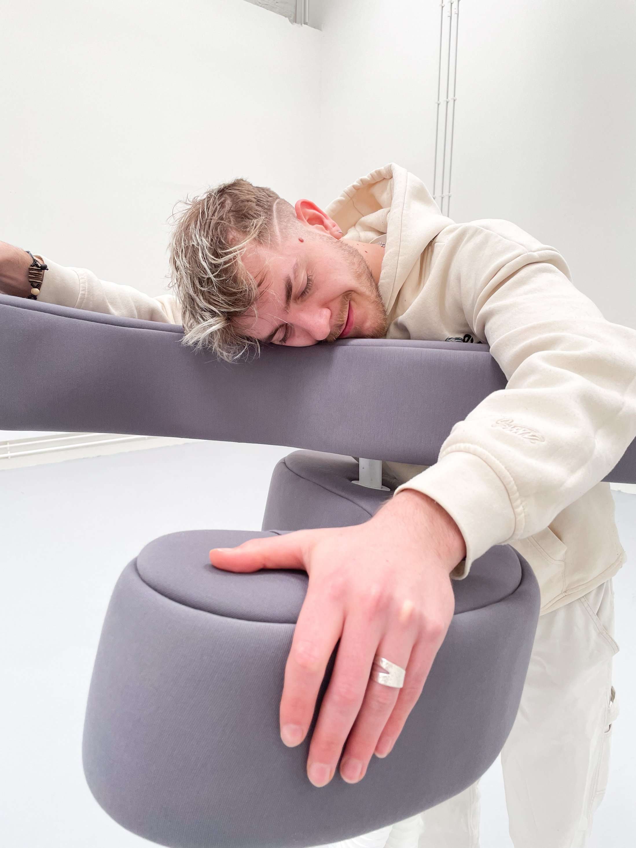 Engaging with Embrace is an intimate experience, the user steps into its open arms, instinctively reaching out to grip both the padded top and bottom arms. The device responds to the user's input, requiring a deliberate application of force to achieve the desired squeezing motion of an embrace. Upon completing their embrace, the user can release their grip, prompting the homing mechanism to gracefully retract its arms to their original position.