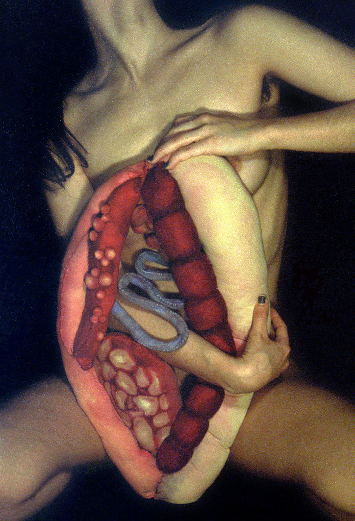 Photograph of woman holding an organ-like soft sculpture in front of her body