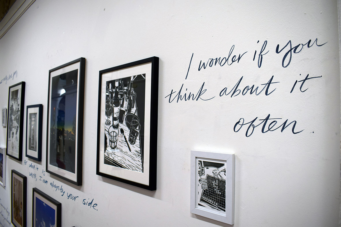 Handwriting on the wall surrounded by framed prints