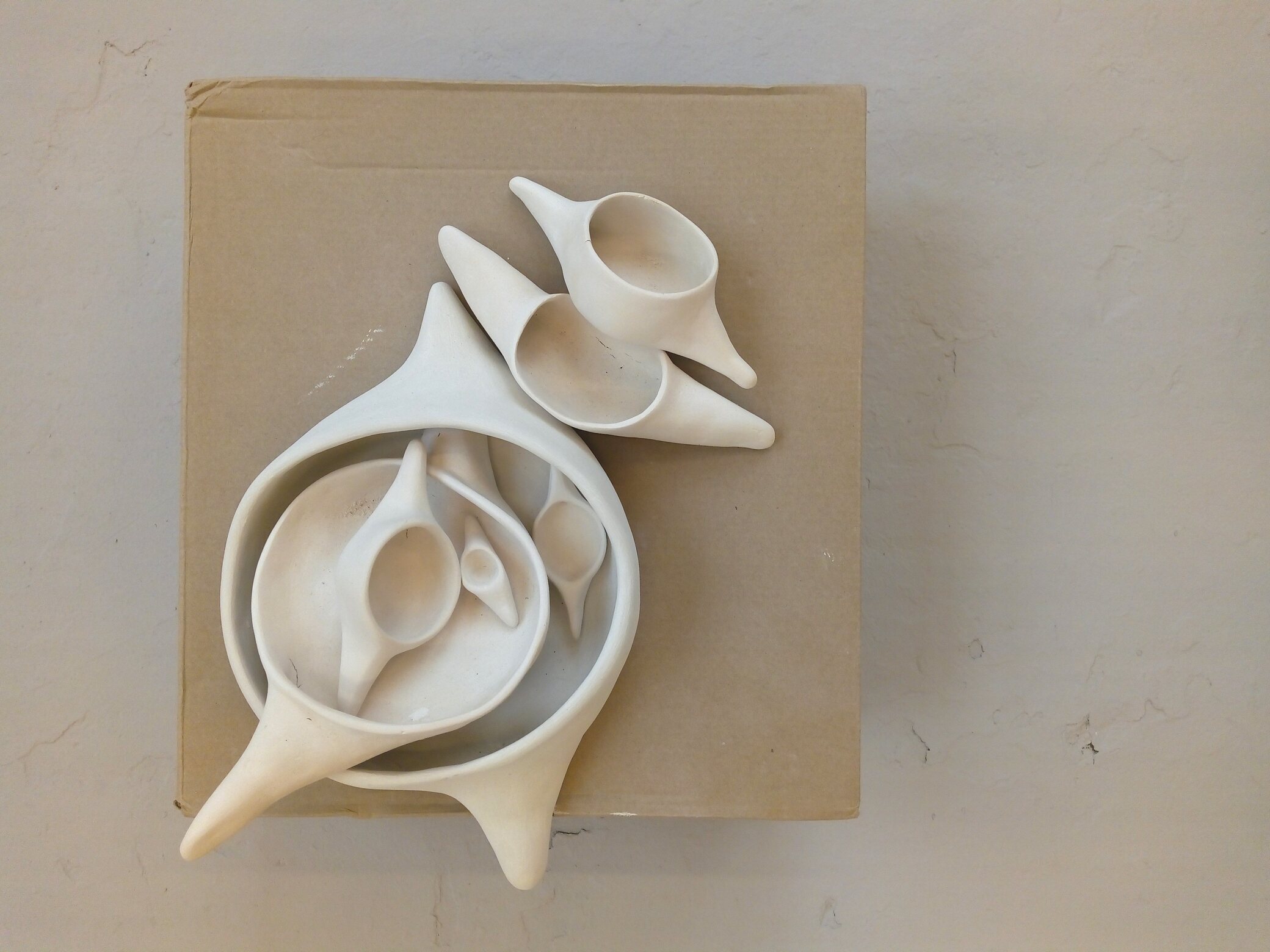 A group of white ceramic vessels resembling vertebrae