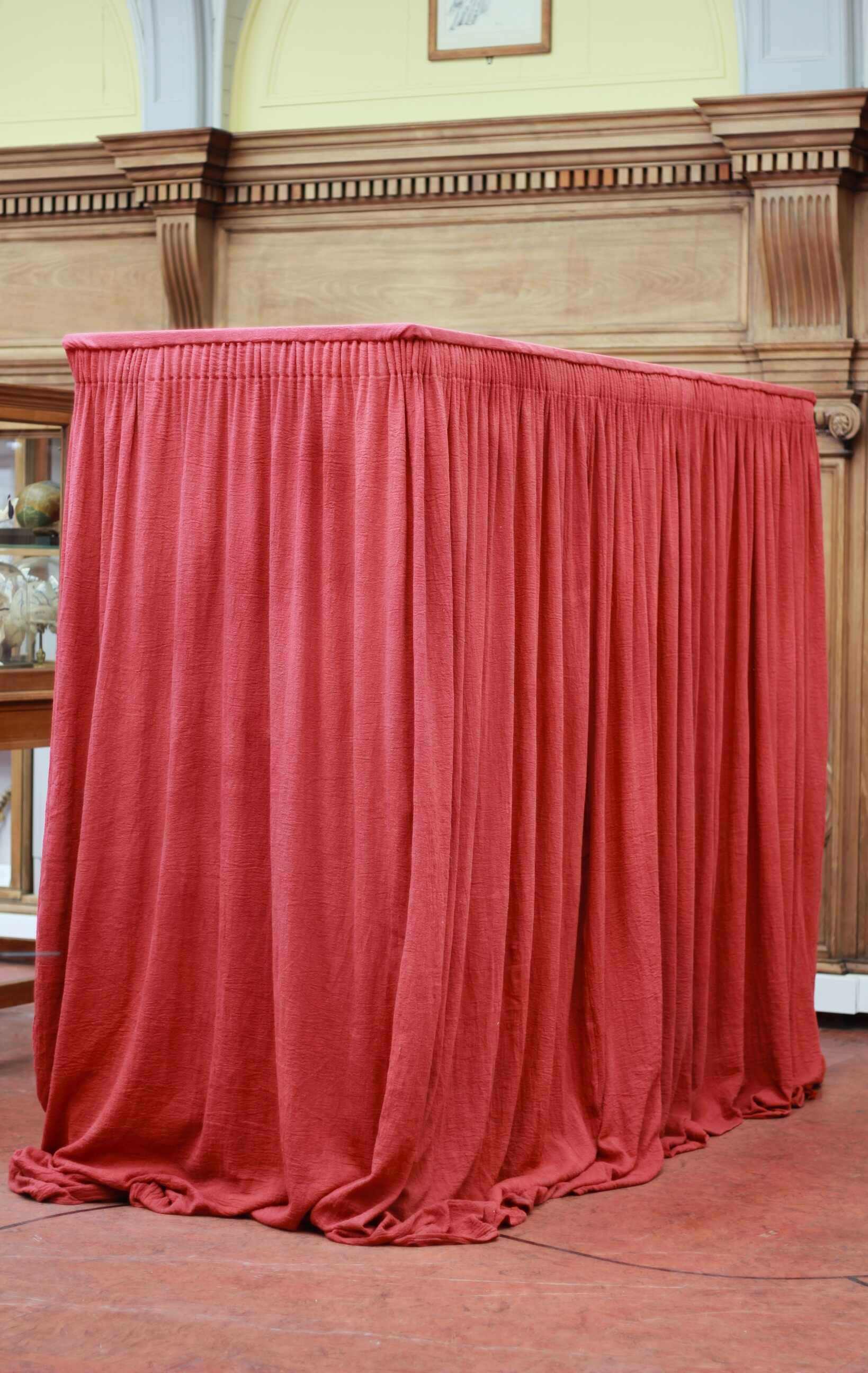 Large anatomy specimens cabinet, shrouded with dense red curtaining.