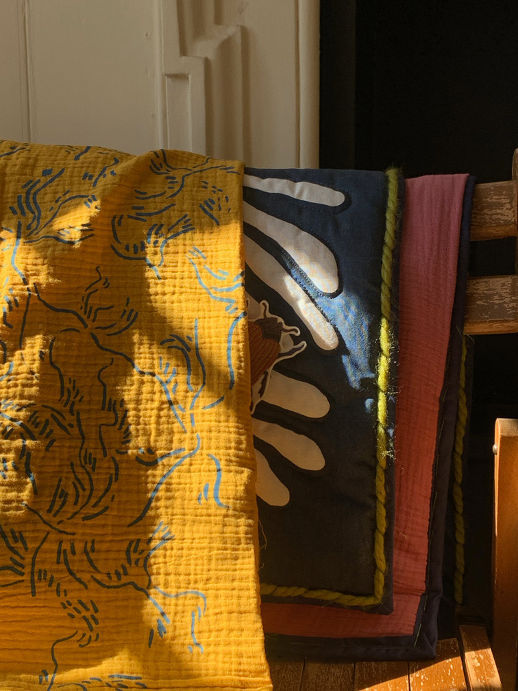 Two printed textiles pieces folded over chair