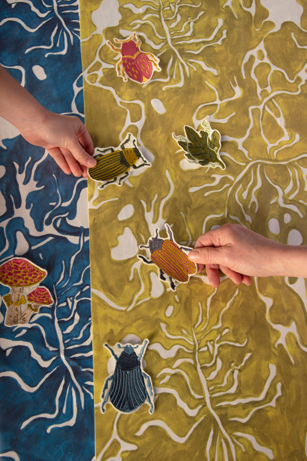 Two hands placing patches onto digitally printed fabric