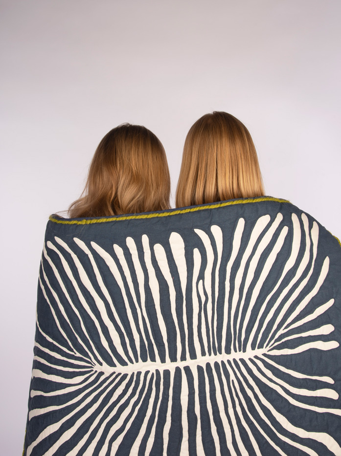 Two women underneath a quilt