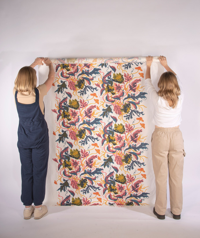 Two women holding up a repeated length