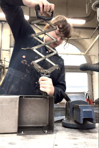 Katherine is pop riveting the sides of the periscope together