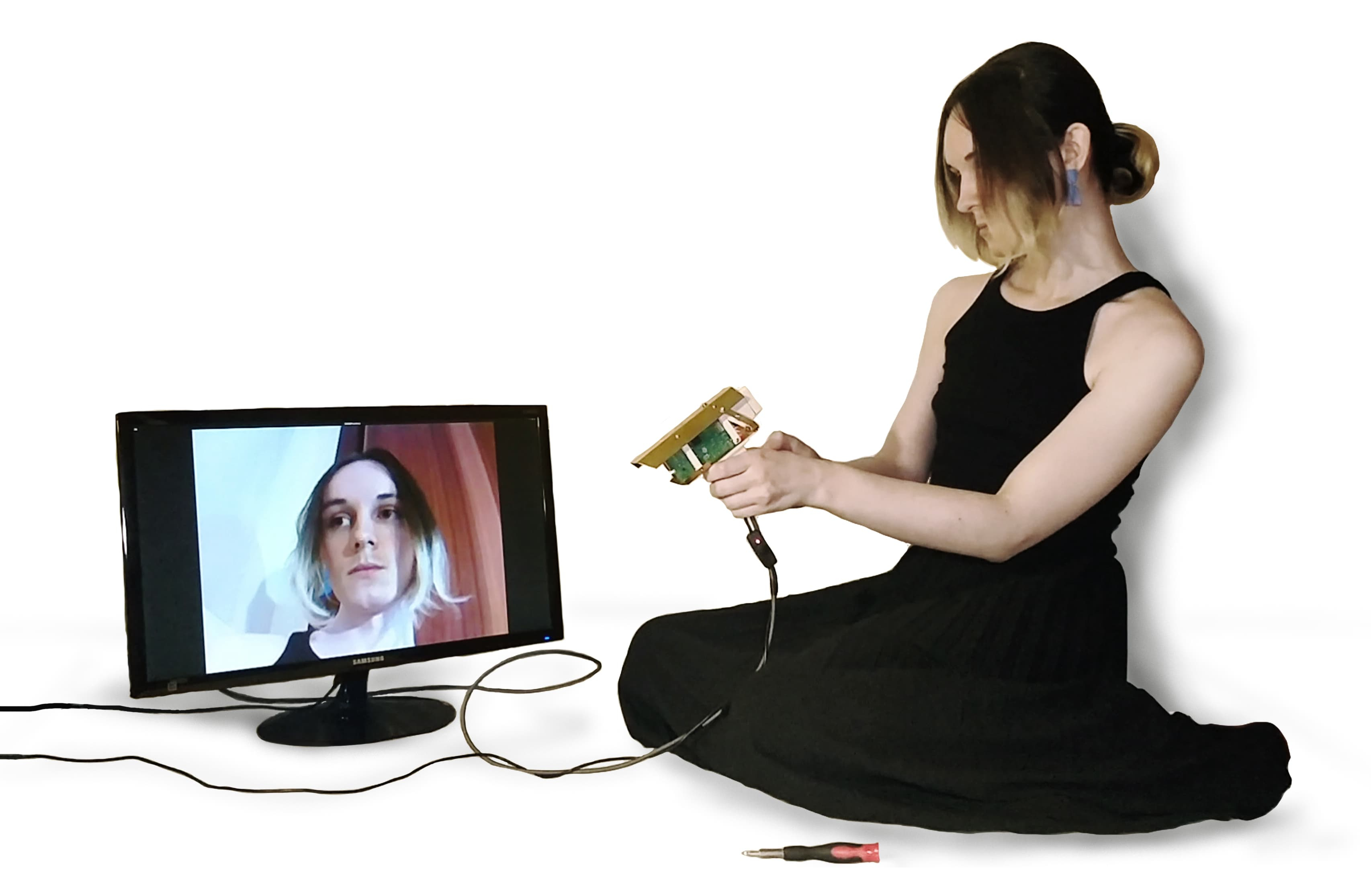 Designer pointing the camera at herself, looking at her face on a screen
