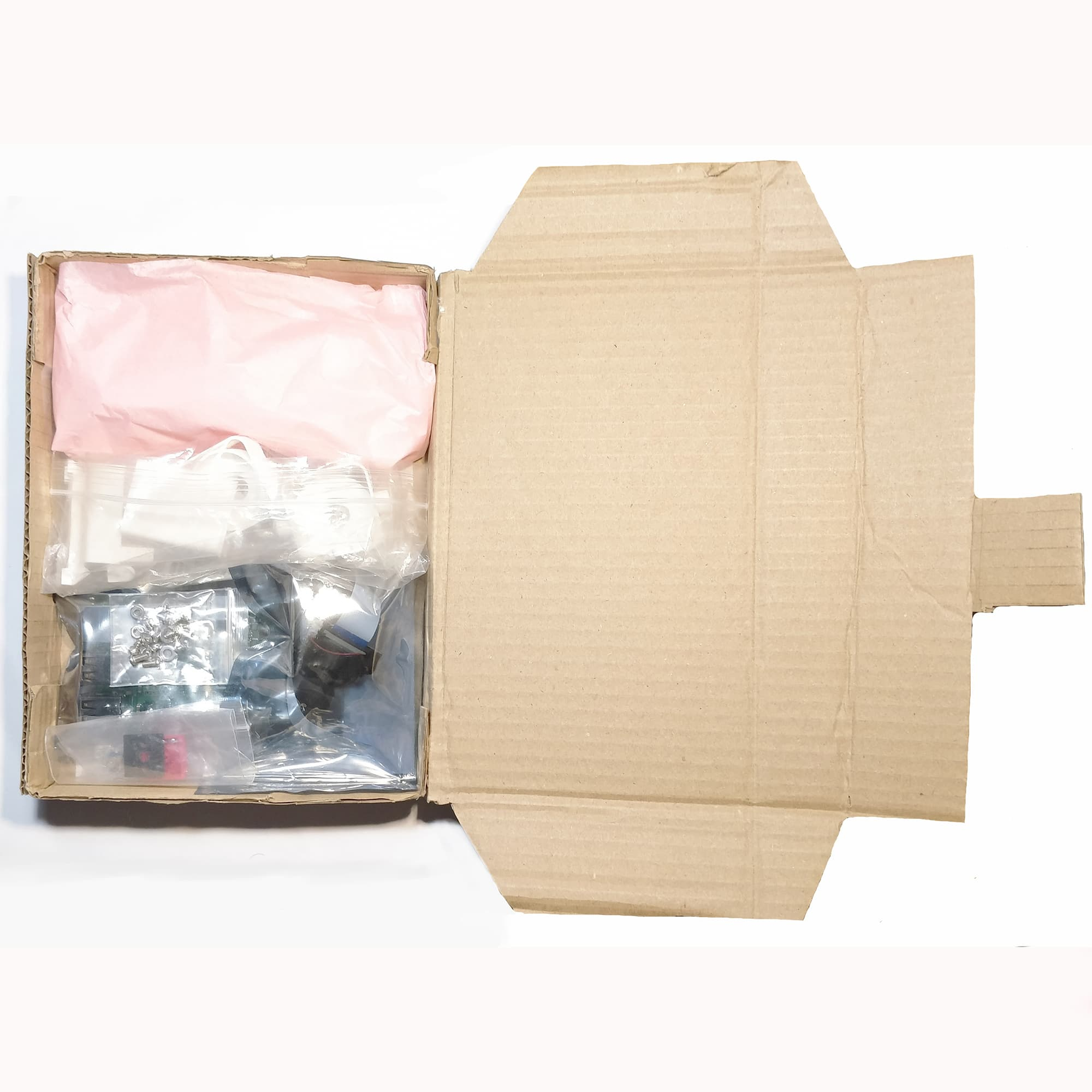 Camera parts in a packaging box, pieces in little bags, the brass parts wrapped up in tissue paper