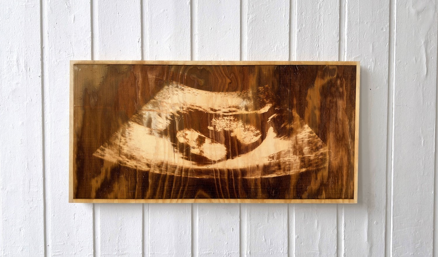 Laser-etched sonogram on a sheet of plywood 