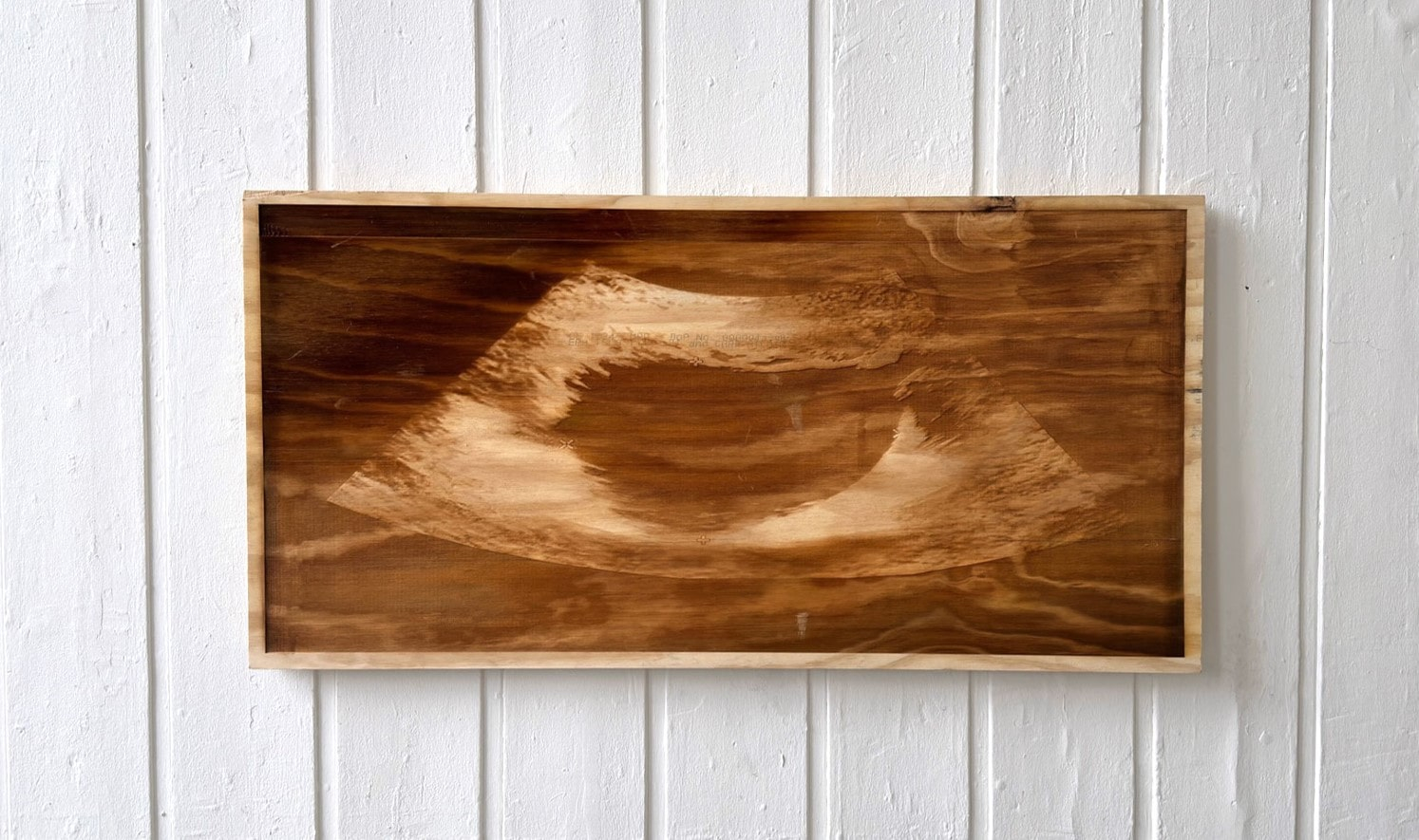 Laser-etched sonogram on a sheet of plywood 