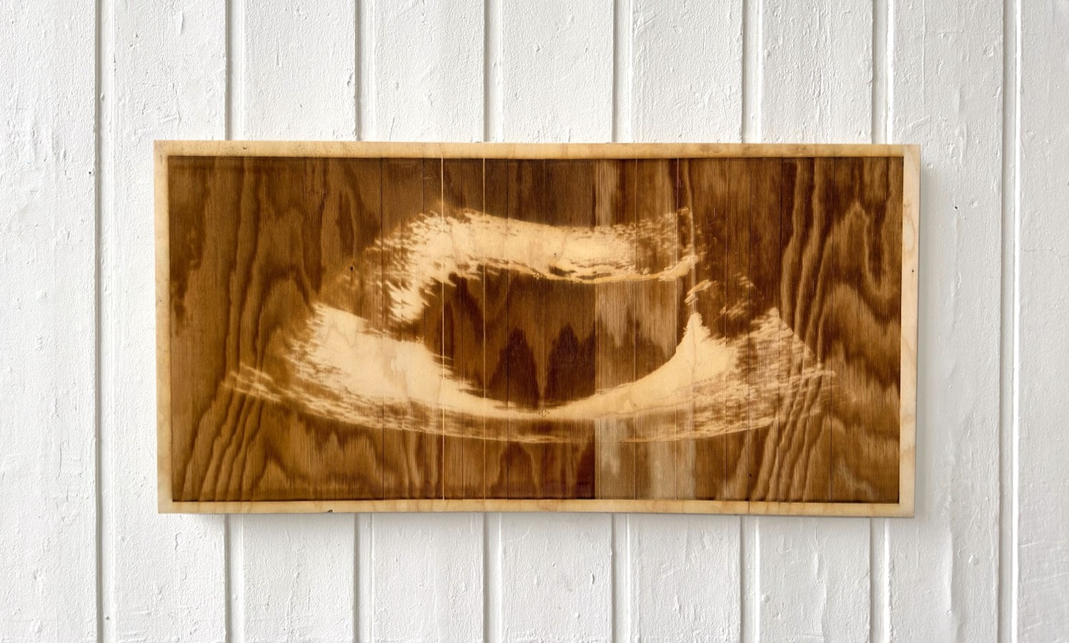 Laser-etched sonogram on a sheet of plywood 