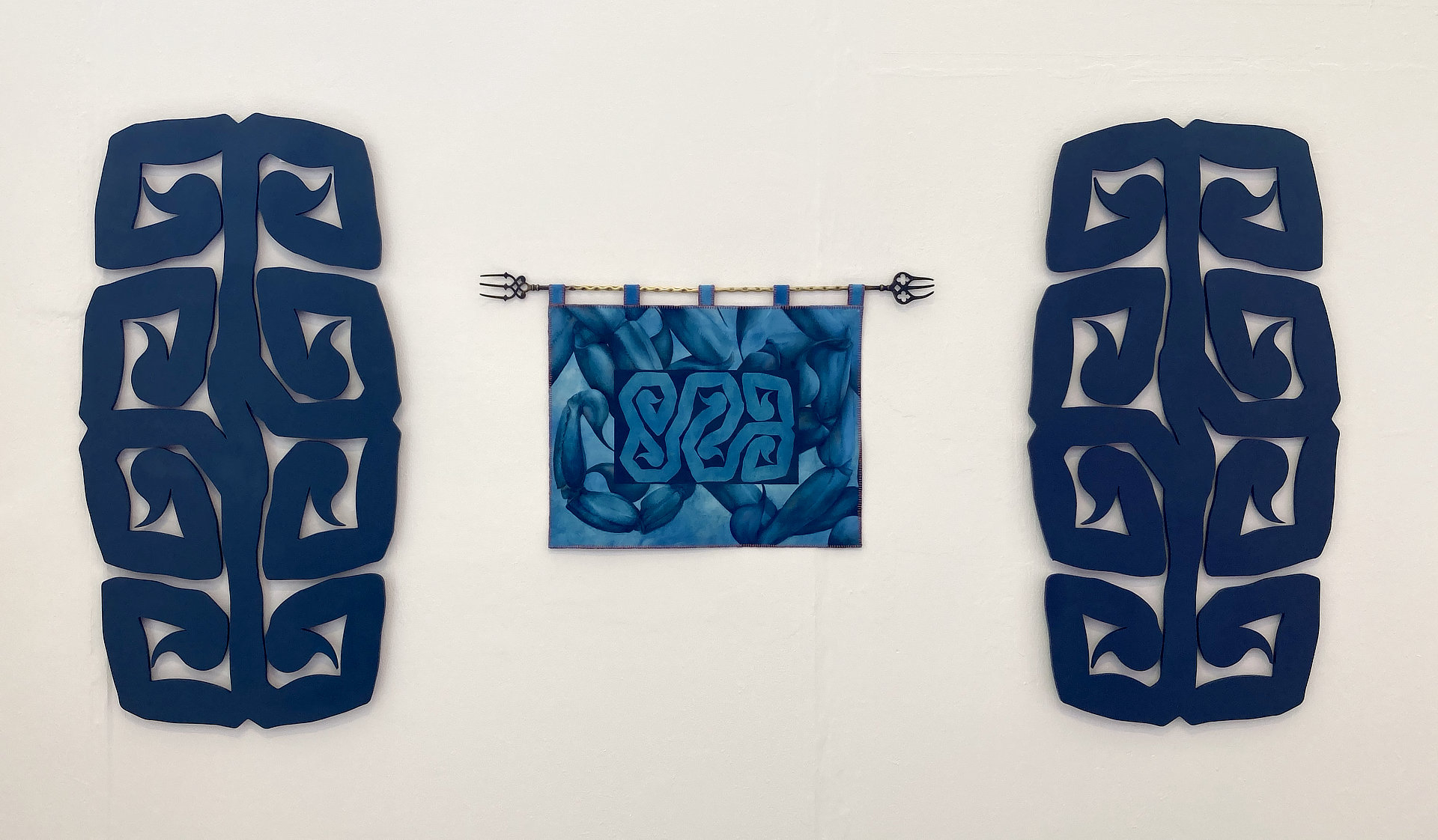 An installation shot of three works from my project, OCD and Other Tails, with a tapestry hung centrally between two large ornamental wood cut outs