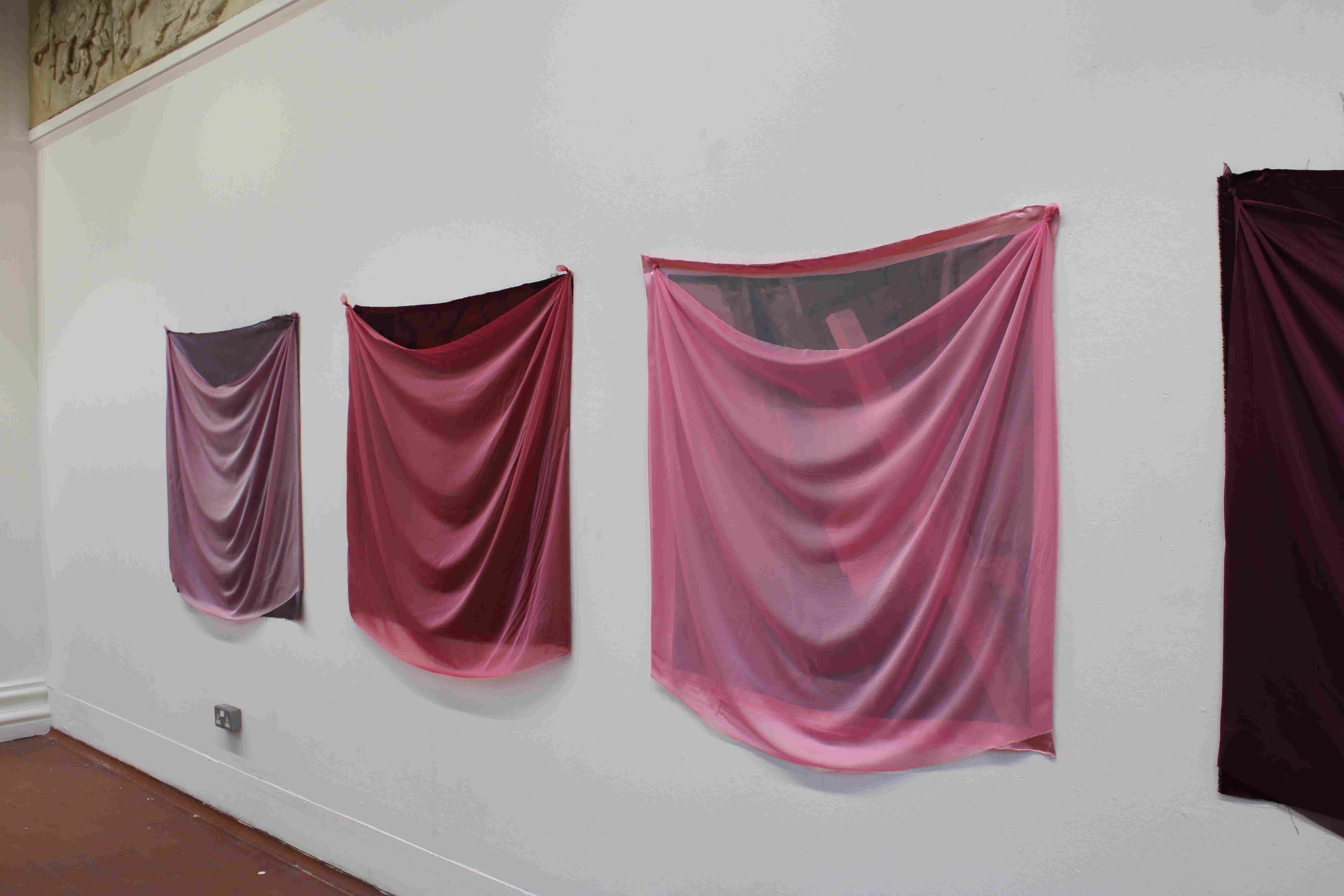 3 fabric squares on a wall with pillars 